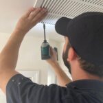 Dr. Duct technician cleaning an air duct vent