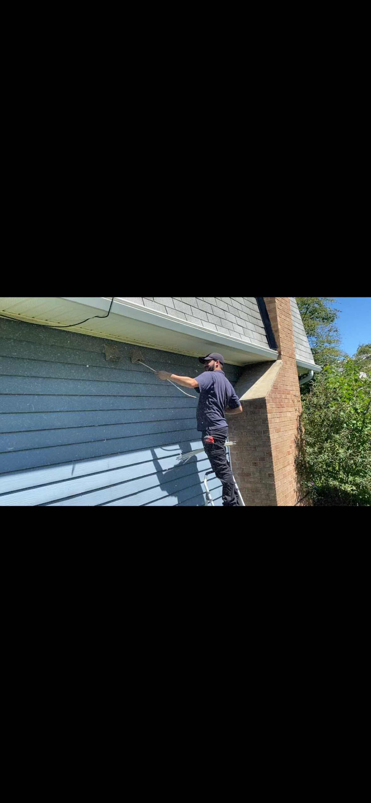 Dr. Duct technician cleaning an exterior dryer vent with rods