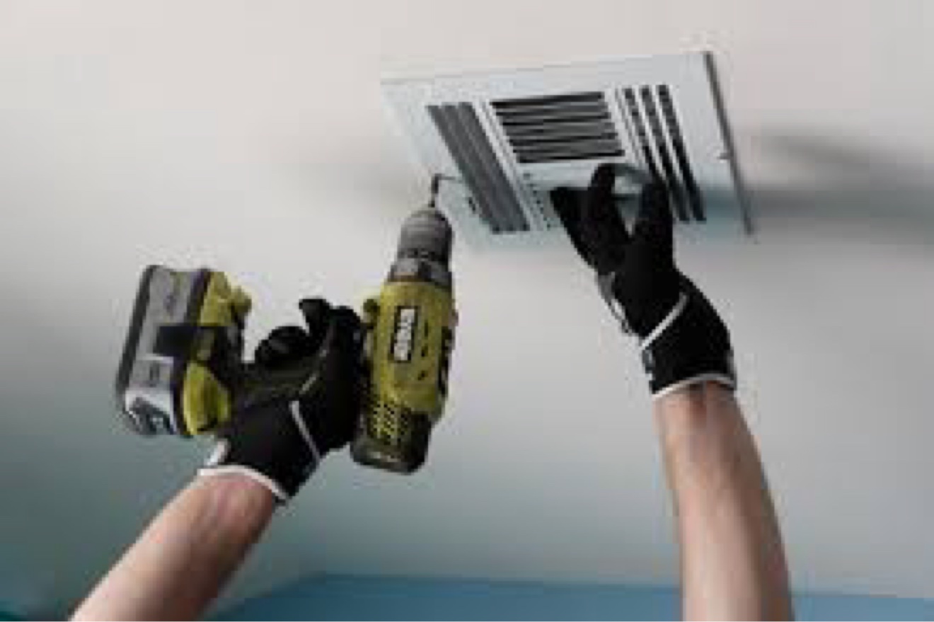 Technician cleaning an air duct vent register